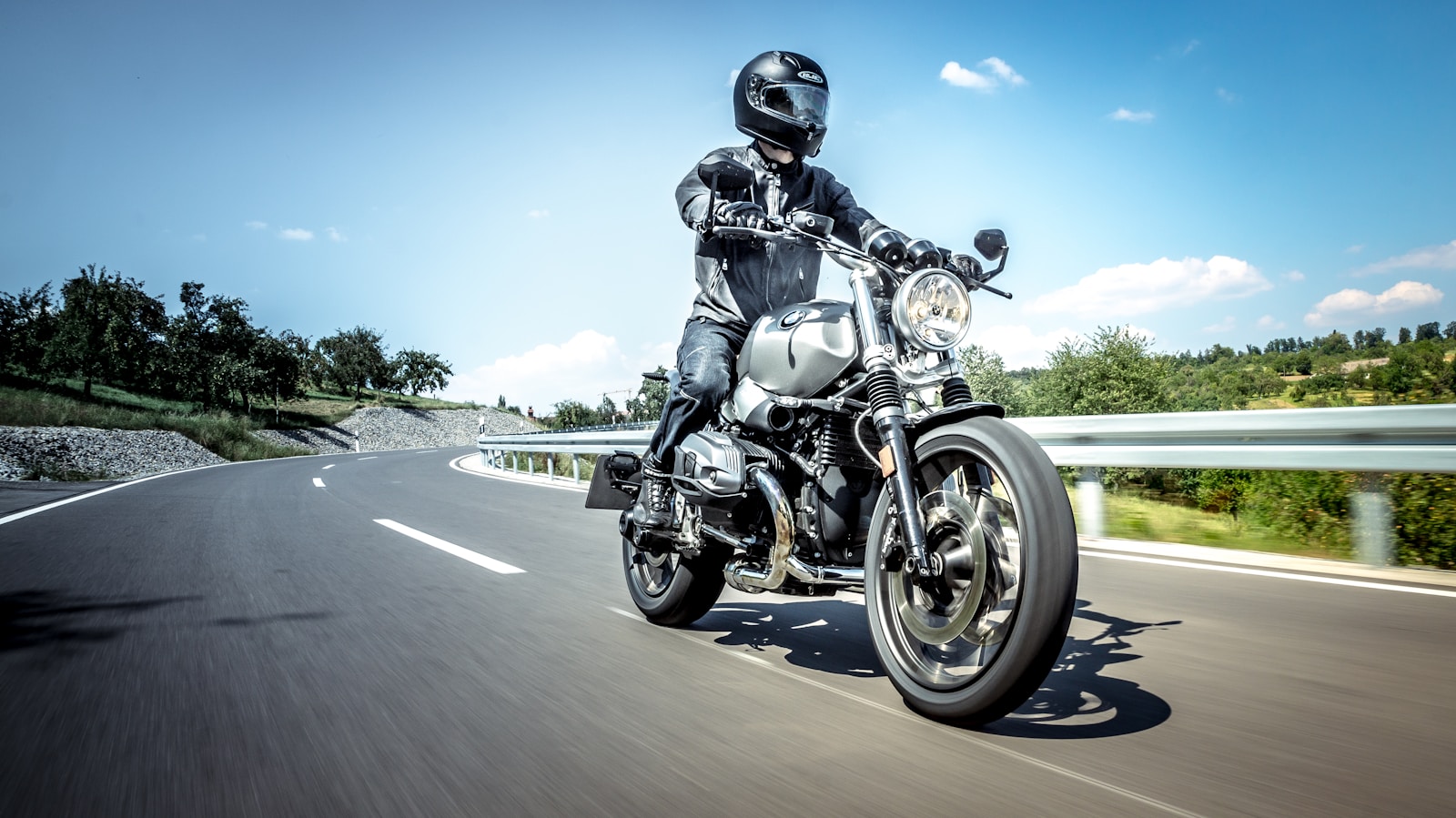 man in black helmet riding on black motorcycle on road during daytime motorcycle